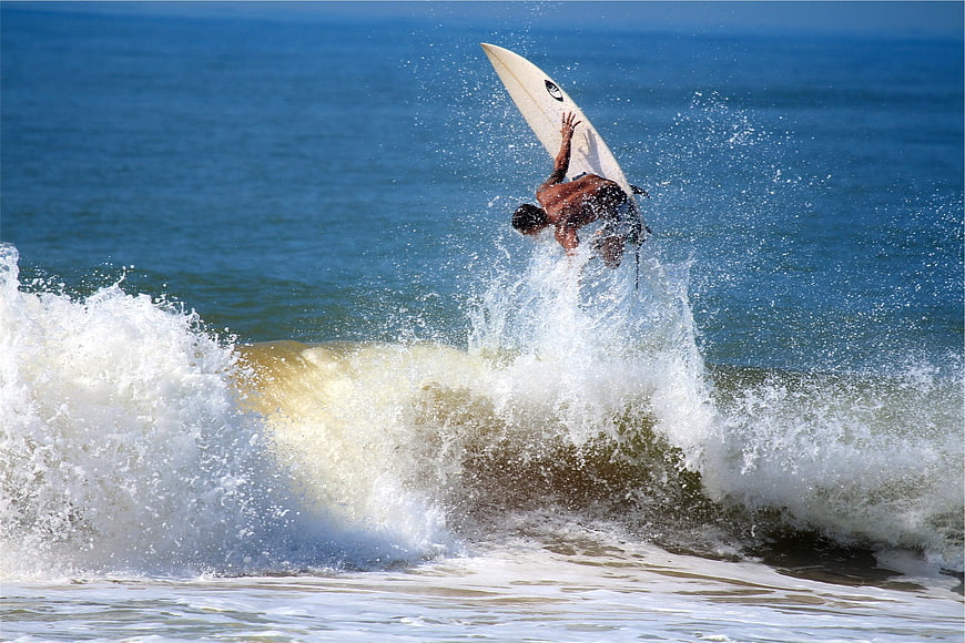 Surfer performing aerial maneuver on ocean wave