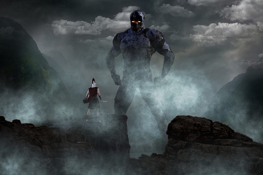 Fantasy warrior facing giant stone monster in misty mountains