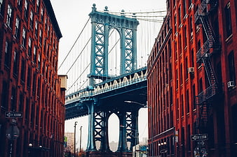 Manhattan Bridge framed by red brick buildings in DUMBO Brooklyn