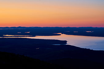 Serene Sunset Over Coastal Lakes and Forested Hills