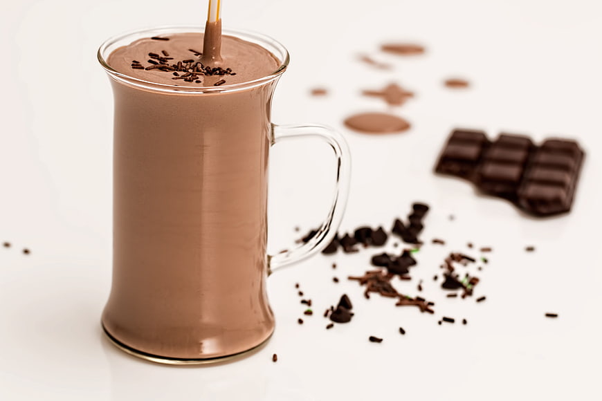 Rich Chocolate Milkshake in Glass with Sprinkles and Chocolate Bar