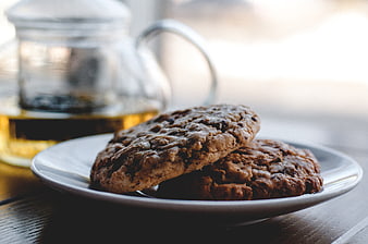 Homemade chocolate chip cookies on a white plate with tea