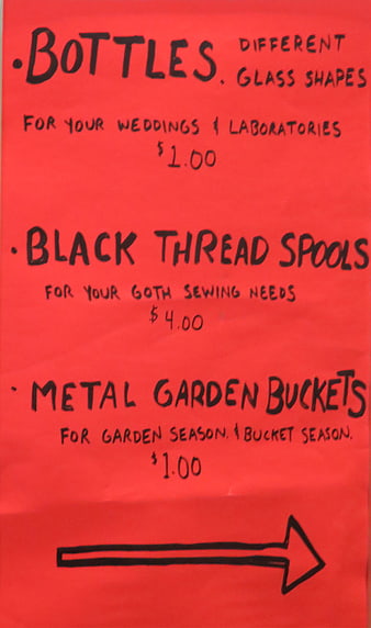 Handwritten red sale sign for bottles, thread, and buckets