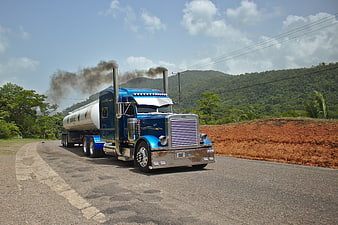 Blue Peterbilt Semi-Truck Hauling Tanker On Rural Road