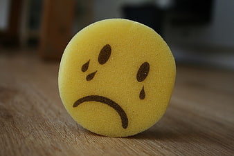 Sad Yellow Sponge Emoticon on Wooden Surface