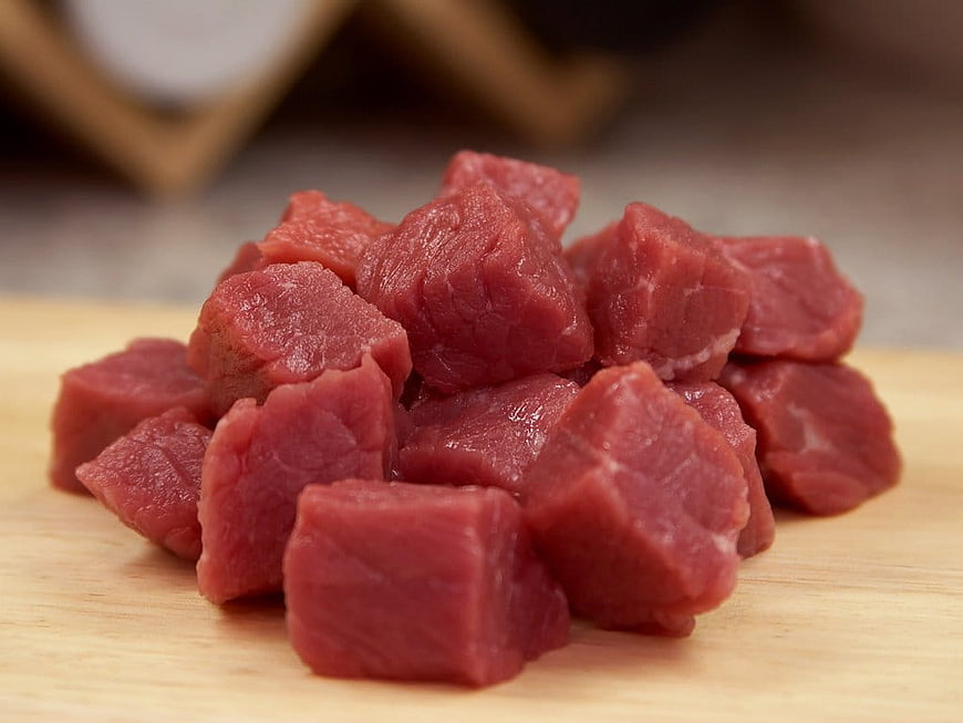 Fresh Raw Beef Cubes on Wooden Cutting Board