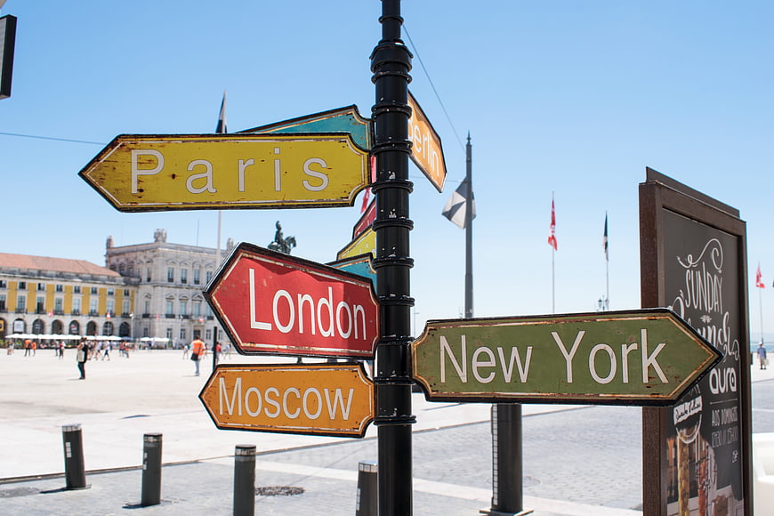Colorful Directional Signs Pointing to Paris London New York