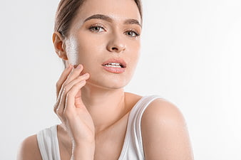 Close-up portrait of a woman touching her smooth skin