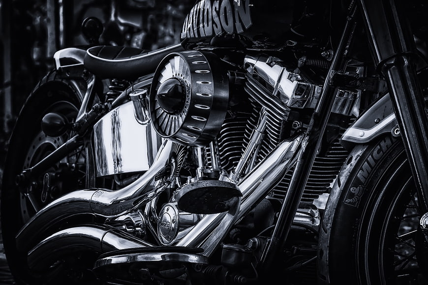 Black and white close-up of a Harley Davidson motorcycle engine and chrome details