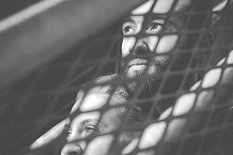 Black and white portrait of couple behind mesh shadows