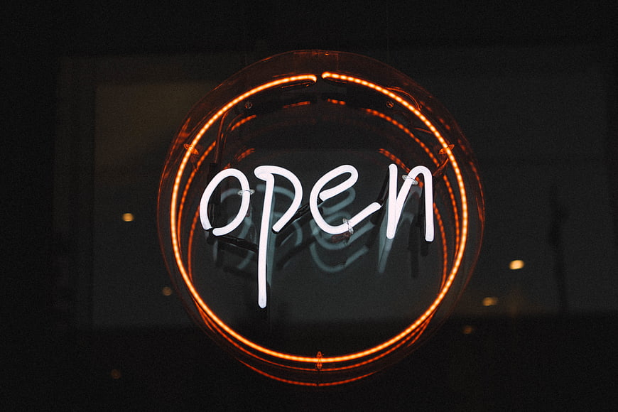Glowing Neon Open Sign in Dark Window