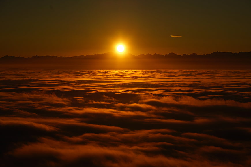 Golden Sunrise Over Sea of Clouds and Mountain Silhouette