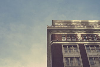 Vintage Corner of Classic Brick Building Against Blue Sky
