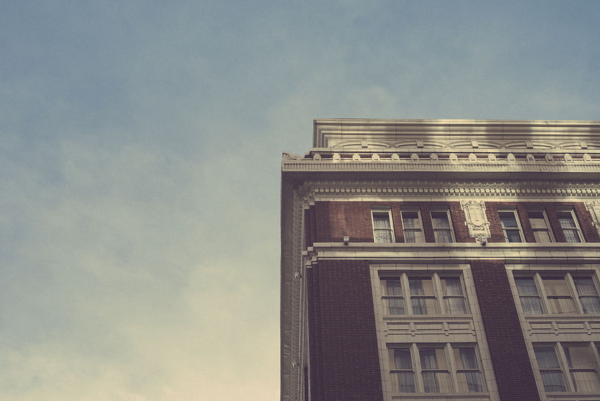 Vintage Corner of Classic Brick Building Against Blue Sky