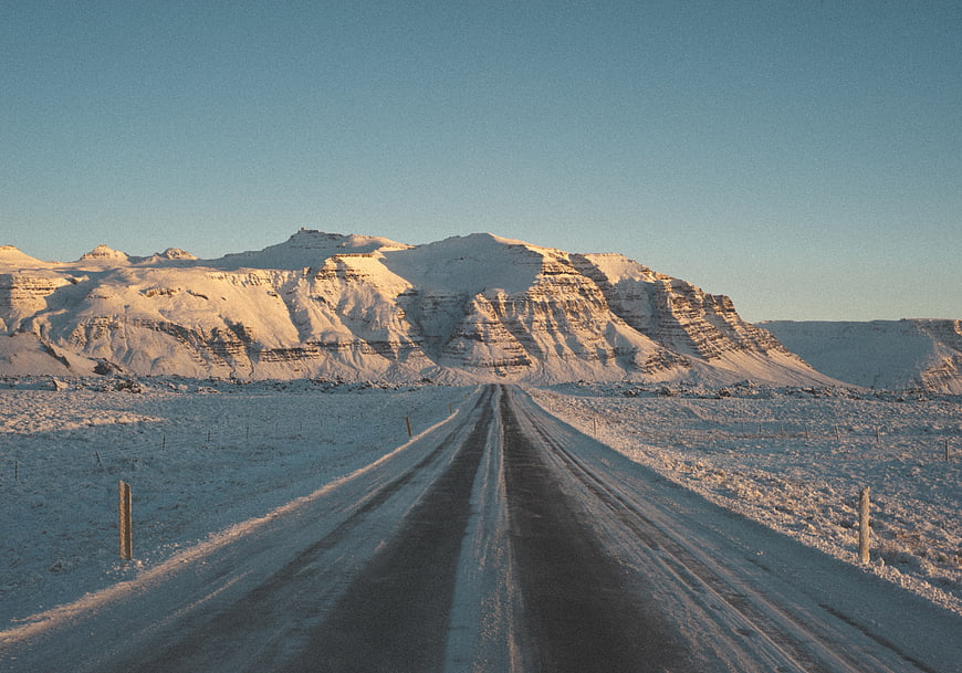 Snowy road leading to majestic winter mountain landscape