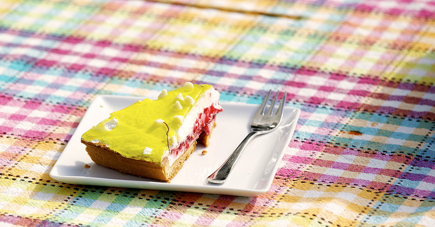 Slice of Green Glazed Cake on Colorful Plaid Tablecloth