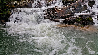 Rushing Whitewater Rapids Flowing Over Dark Rocks
