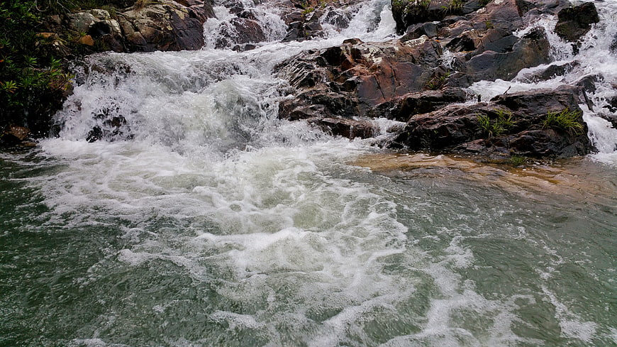 Rushing Whitewater Rapids Flowing Over Dark Rocks