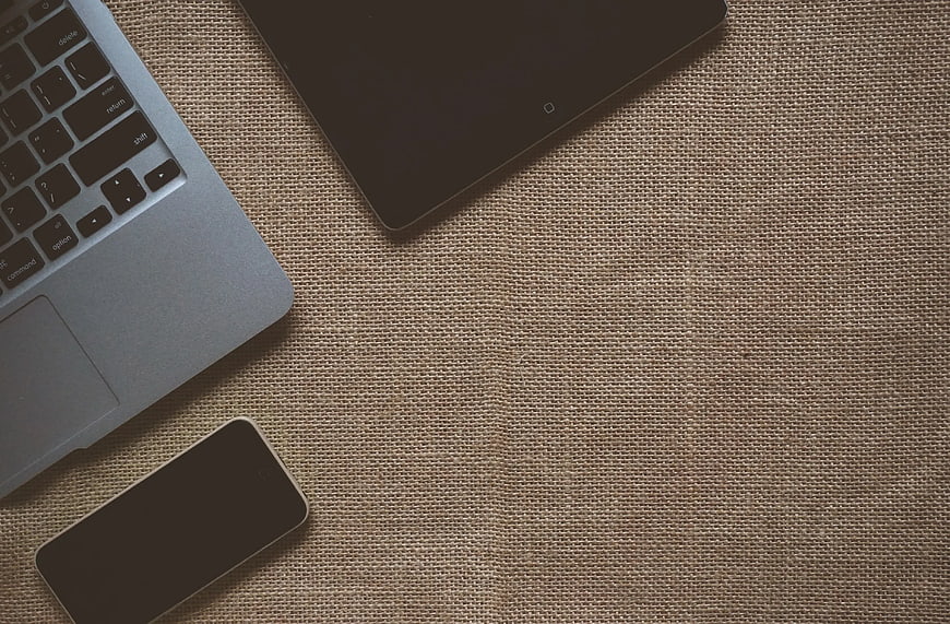 Laptop, Tablet, and Smartphone on Textured Fabric Background