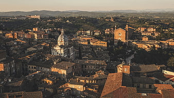 Aerial view of historic Italian town with terracotta rooftops and church domes