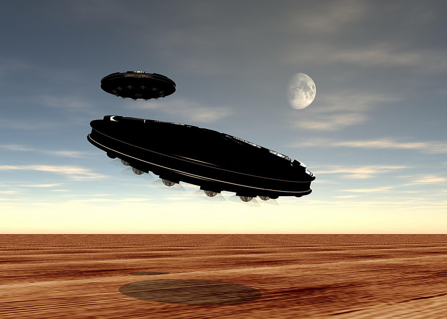 Two UFOs Flying Over Desert Landscape at Sunset