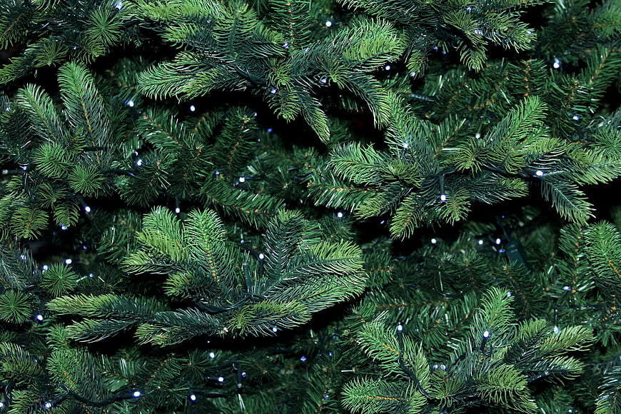 Close-up of artificial Christmas tree branches with white lights
