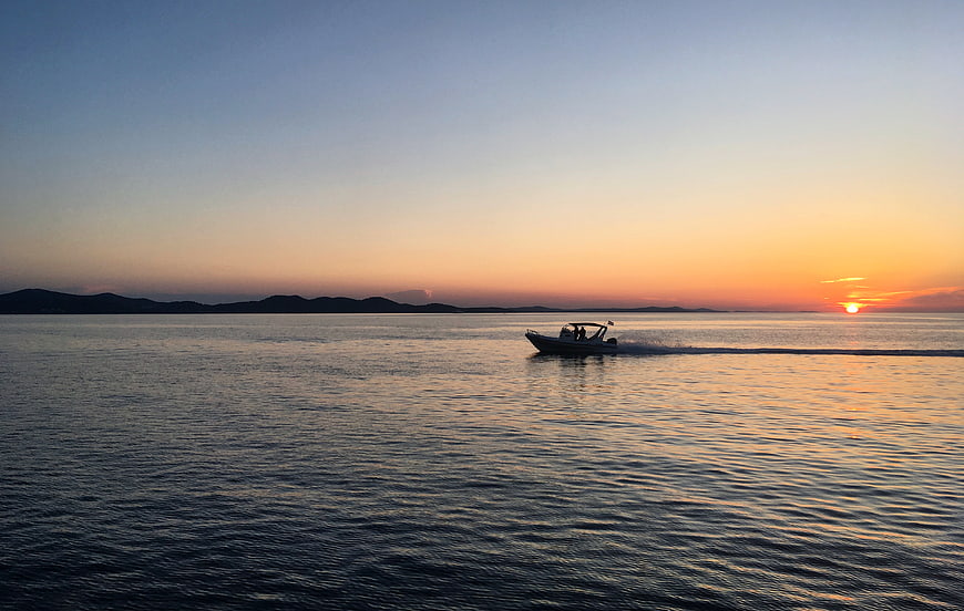 Motorboat Cruising on Calm Sea at Golden Sunset