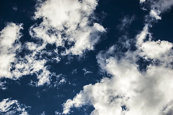 Dramatic white clouds against deep blue sky background