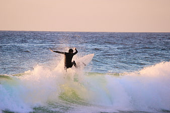 Surfer Riding Wave at Sunset