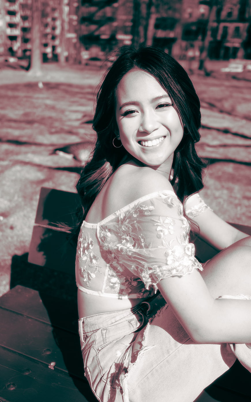 Smiling Woman in Lace Top Sitting Outdoors