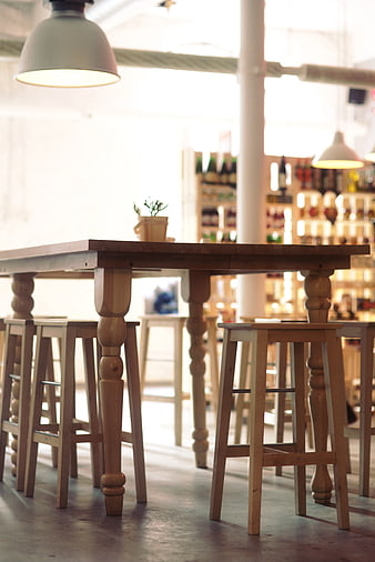 Rustic wooden table and stools in a bright cafe interior