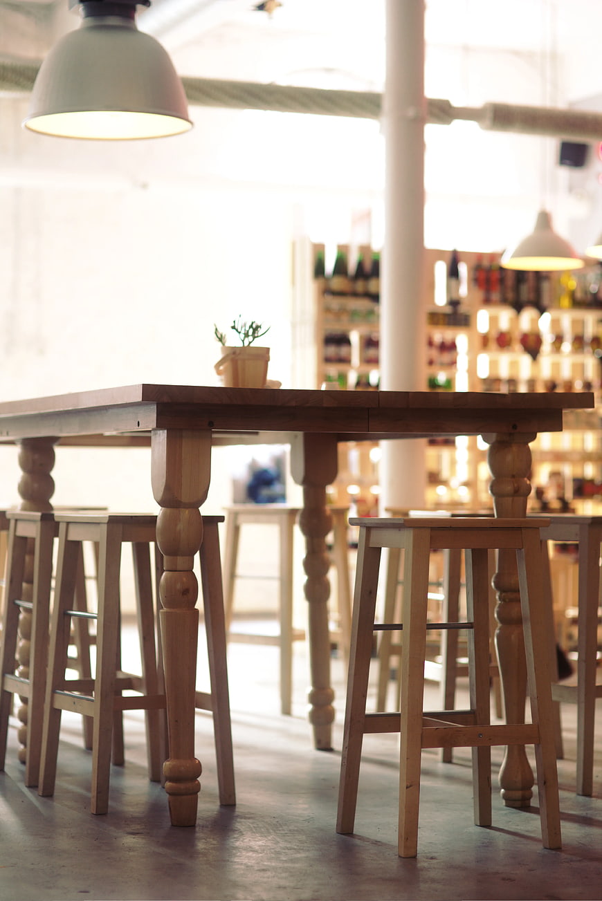 Rustic wooden table and stools in a bright cafe interior
