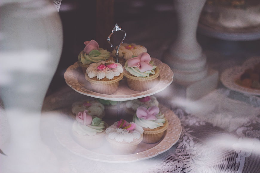 Vintage tiered stand with floral cupcakes and lace tablecloth