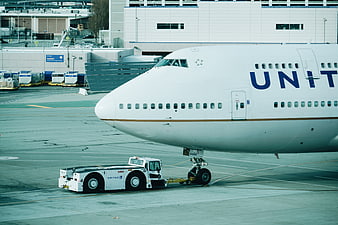 United Airlines Boeing 747 being towed on airport tarmac