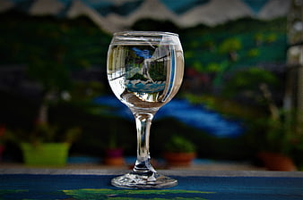 Glass of Water with Landscape Reflection on Blue Table