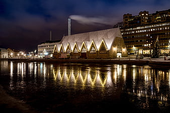 Illuminated wooden church reflecting in water at night
