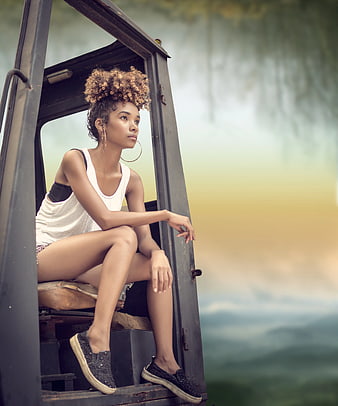 Woman with curly hair sitting in vehicle cabin