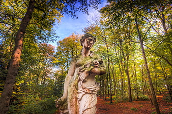 Weathered Stone Statue in Autumn Forest Park