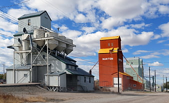 Red and White Grain Elevators in Rural Town Under Blue Sky