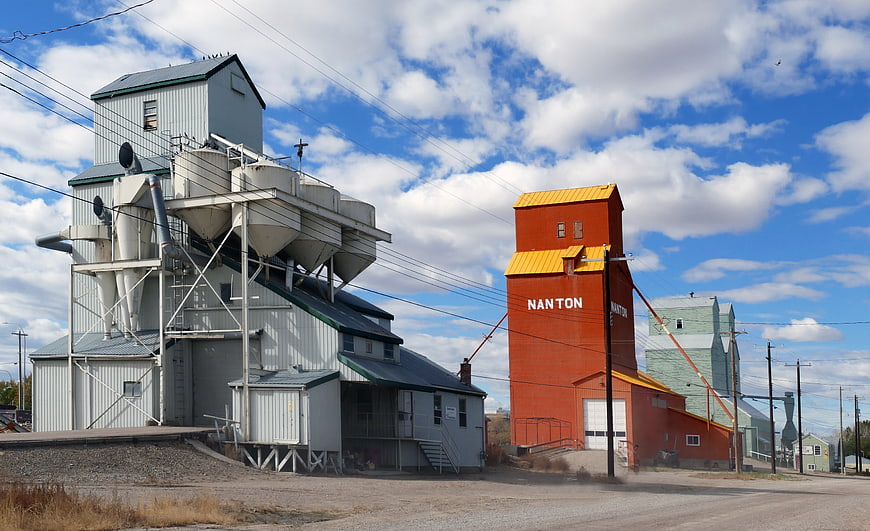 Red and White Grain Elevators in Rural Town Under Blue Sky