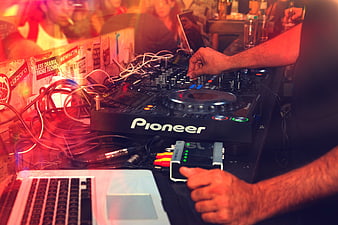 DJ mixing music on Pioneer controller at nightclub party