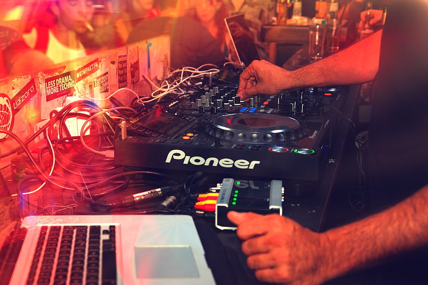 DJ mixing music on Pioneer controller at nightclub party