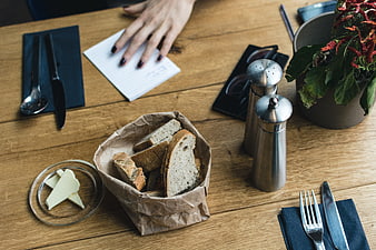 Rustic bread basket and butter on wooden cafe table