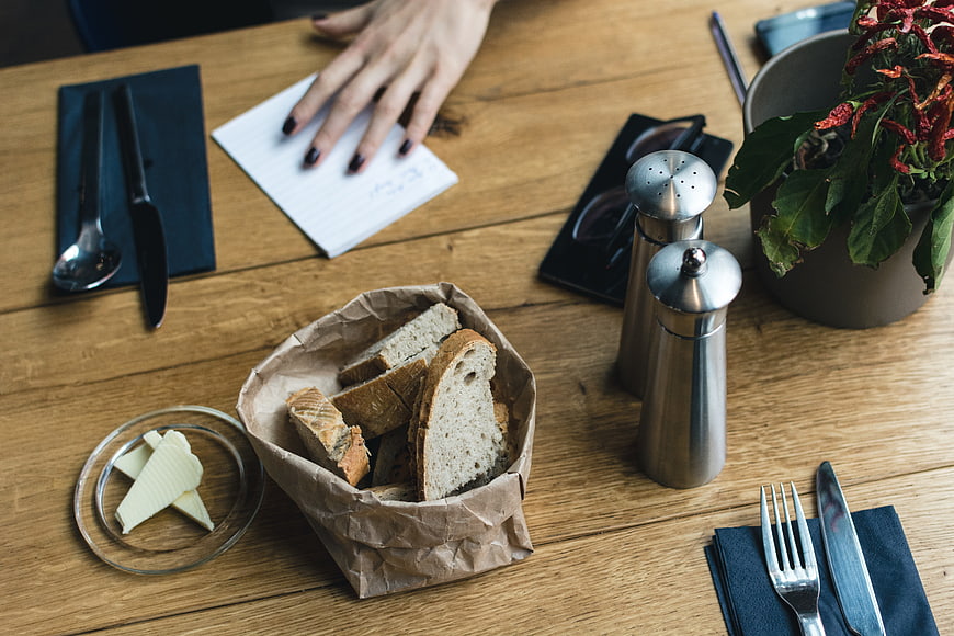 Rustic bread basket and butter on wooden cafe table