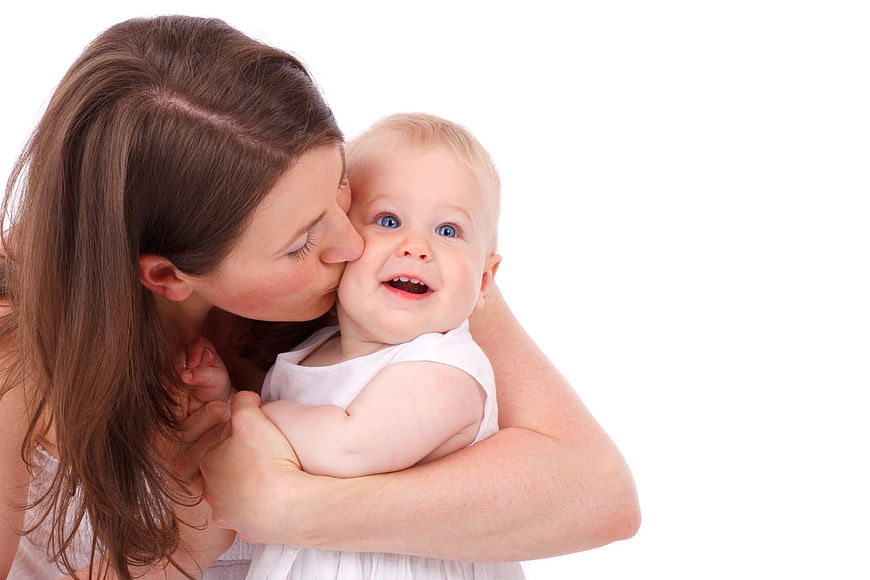 Happy Mother Kissing Baby on Cheek White Background