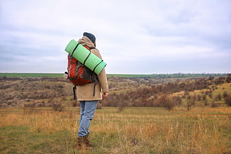 Hiker with Backpack Looking Out Over Autumn Landscape