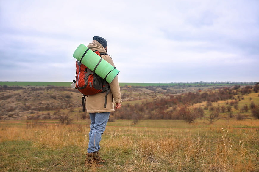 Hiker with Backpack Looking Out Over Autumn Landscape