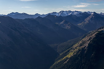 Majestic Mountain Range with Snow-Capped Peaks and Deep Valleys