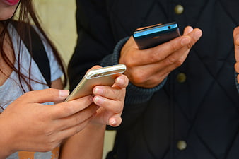 Close-up of two people texting on smartphones
