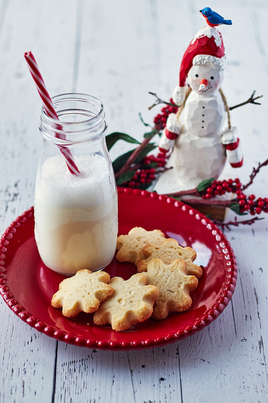 Christmas cookies and milk on red plate with snowman